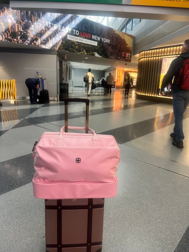 Smaller SwissGear 7739 suitcase with SwissGear Overnight Tote bag (pink) attached to it